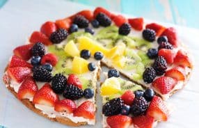 colorful fruit pizza with berries and cream cheese on cookie crust