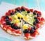 colorful fruit pizza with berries and cream cheese on cookie crust