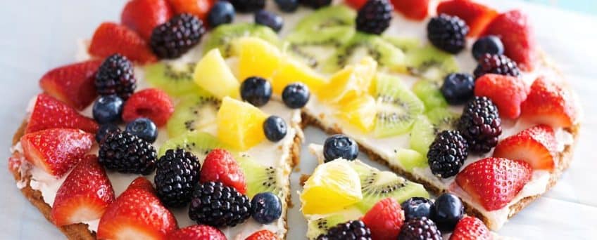 colorful fruit pizza with berries and cream cheese on cookie crust