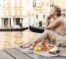 Lovely young woman is having picnic on a wooden pier in the Venice