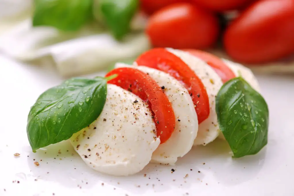 Caprese salad with mozzarella cheese, tomato basil and pepper